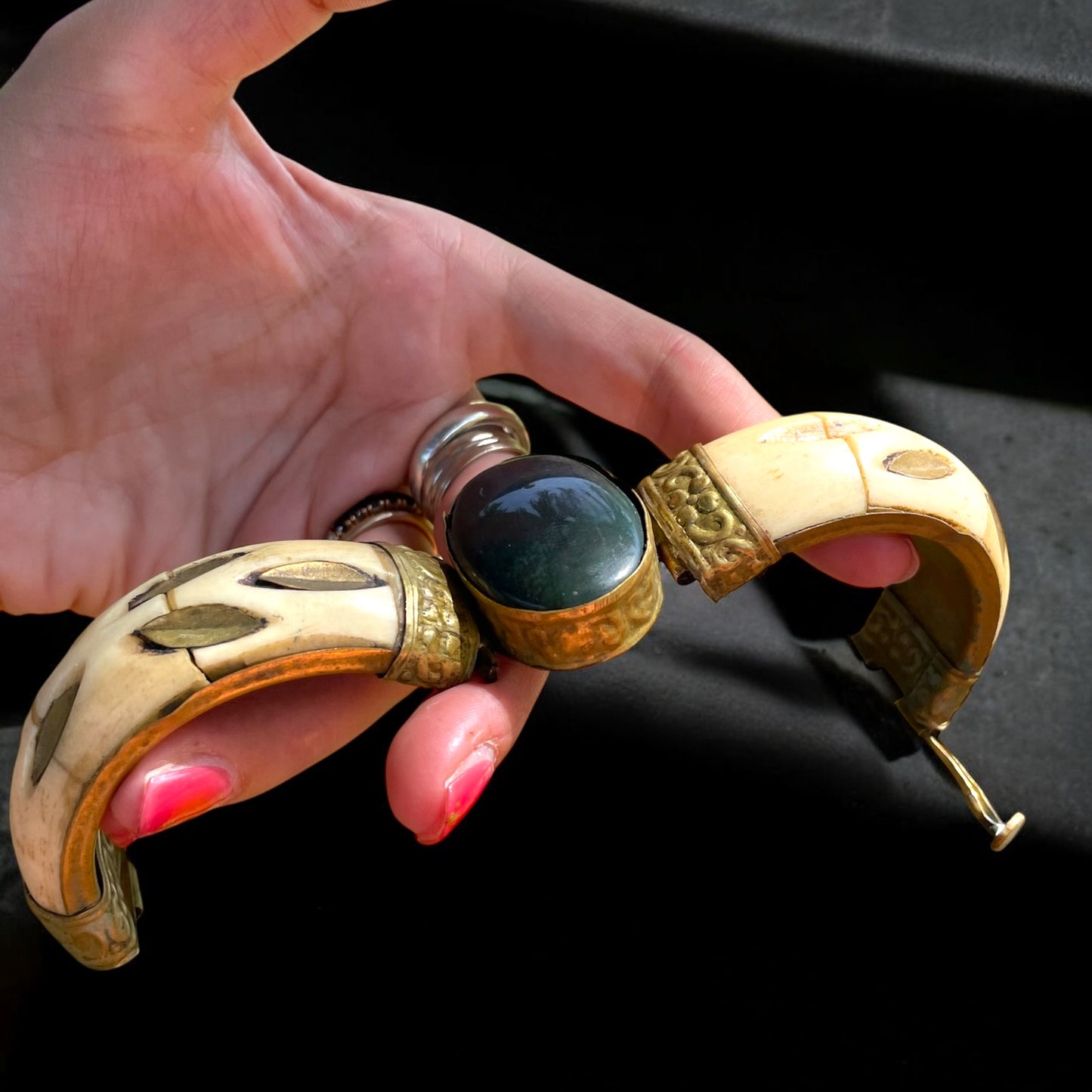 Bracciale rigido in osso con chiusura a baionetta, decorazioni in ottone e cabochon centrale pietra dura