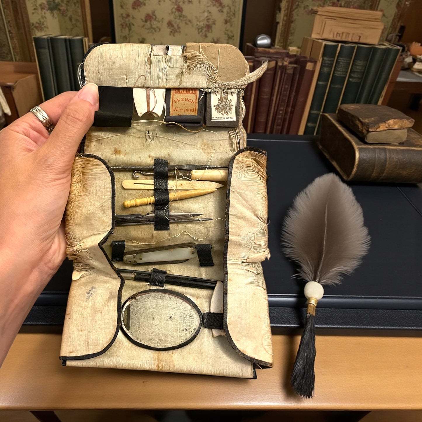 Antico set da cucito vittoriano in bustina, completo di aghi d’epoca, strumenti in ferro, osso e specchietto ovale.