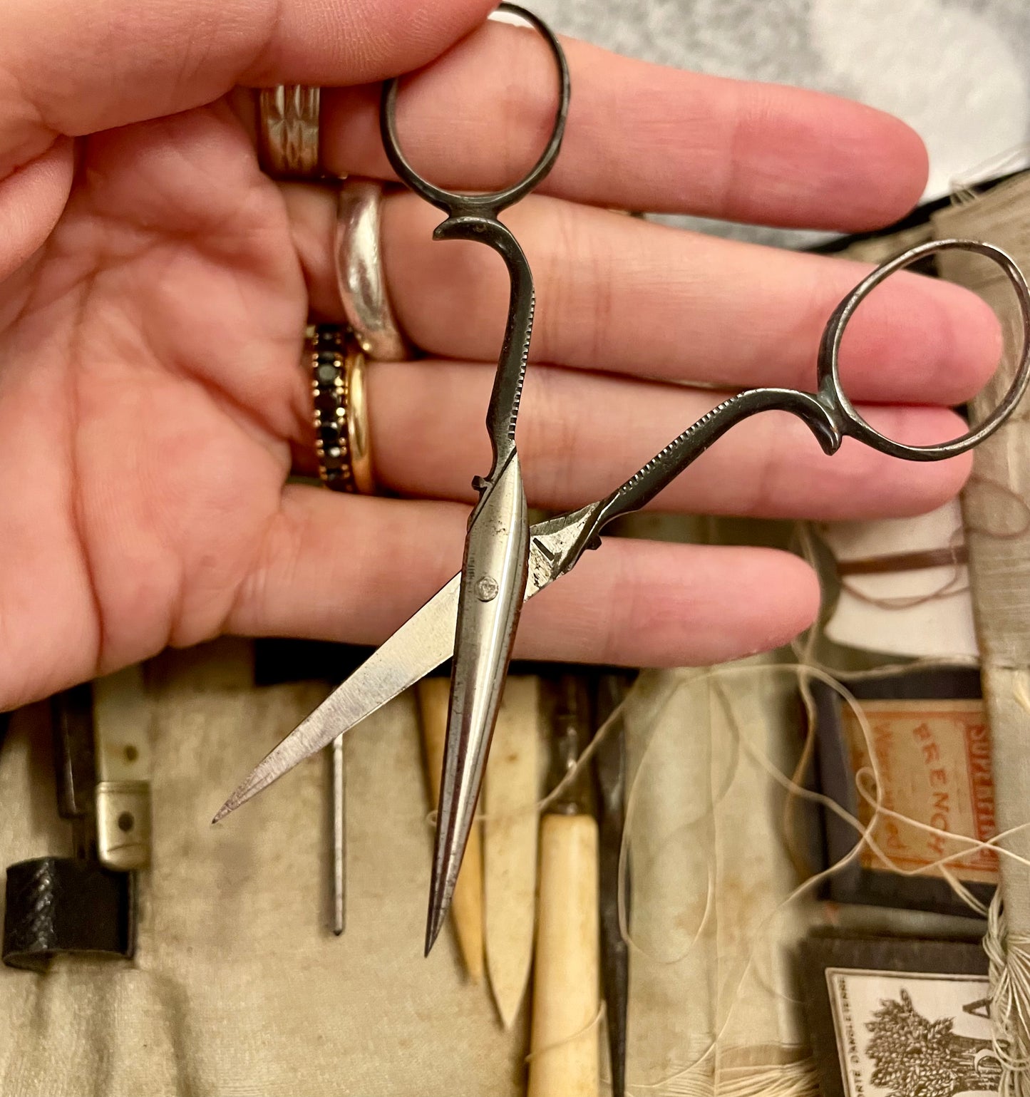 Antico set da cucito vittoriano in bustina, completo di aghi d’epoca, strumenti in ferro, osso e specchietto ovale.