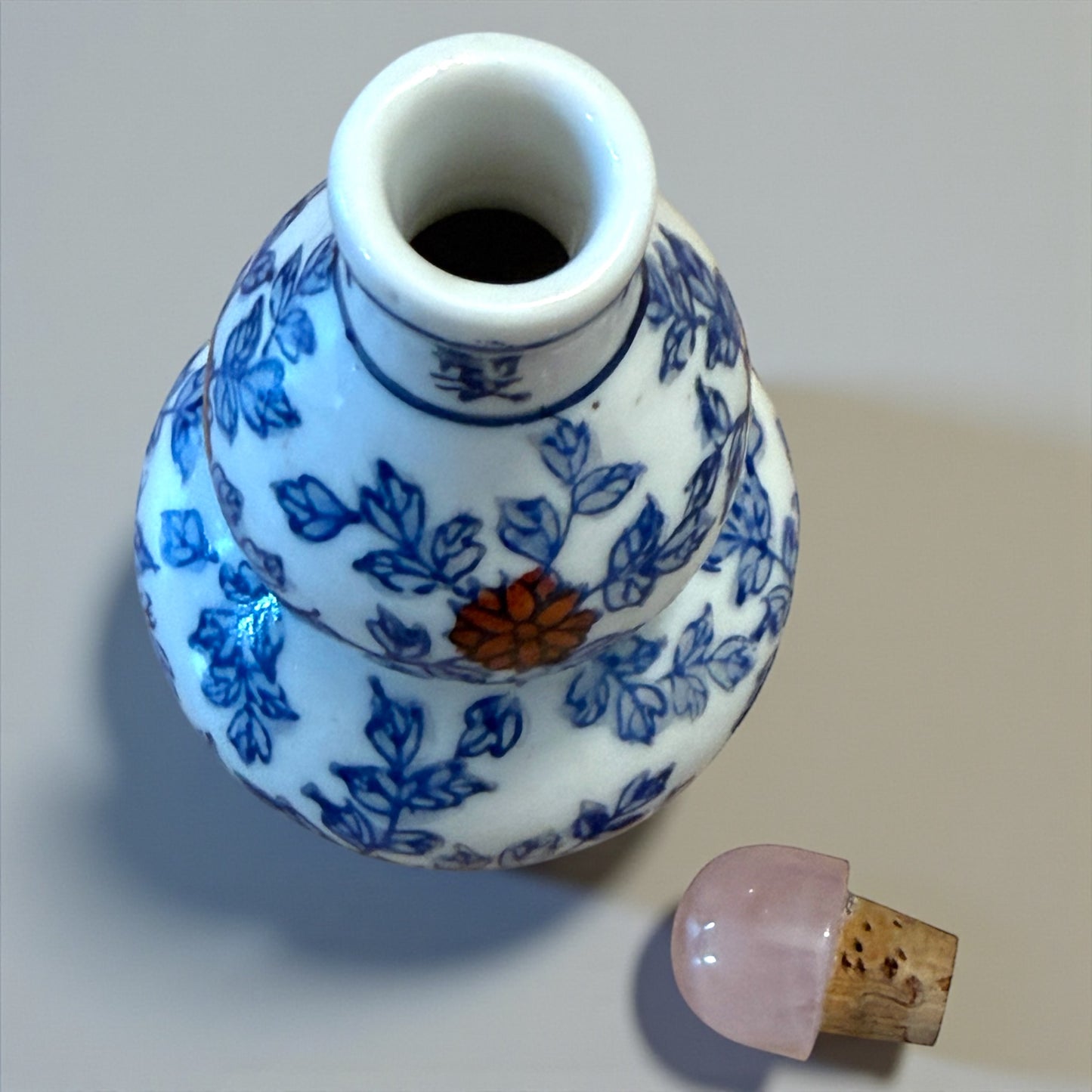 Snuff Bottle in ceramica smaltata a decori rossi e blu, tappo in quarzo rosa