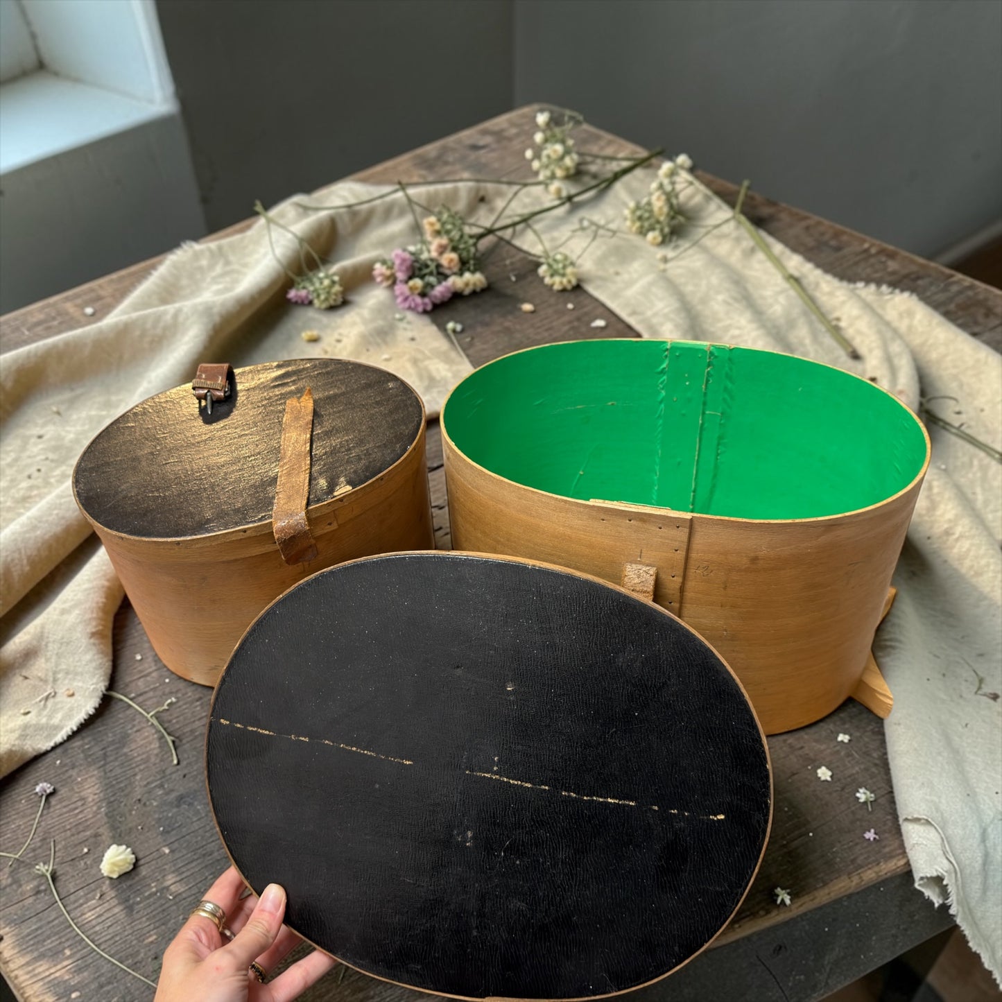 Coppia di antiche cappelliere da modista, foderate in carta verde, con cinghie originali d’epoca