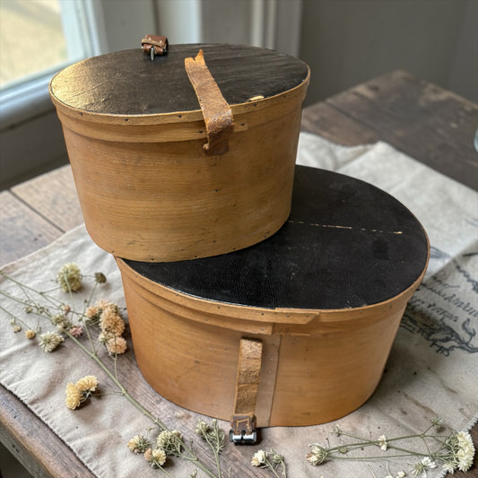 Coppia di antiche cappelliere da modista, foderate in carta verde, con cinghie originali d’epoca