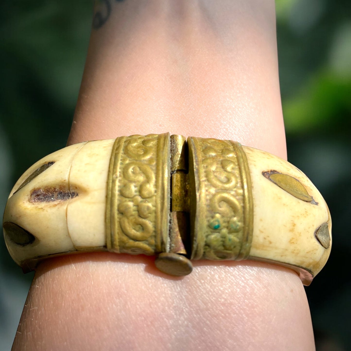 Bracciale rigido in osso con chiusura a baionetta, decorazioni in ottone e cabochon centrale pietra dura
