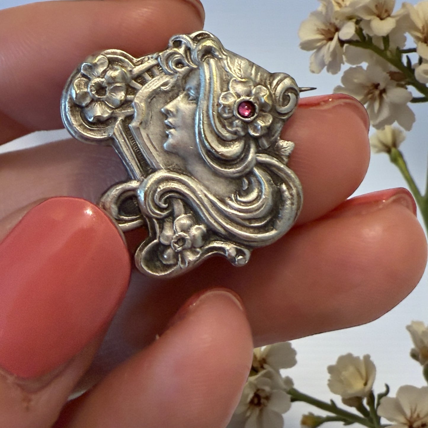 Spilla Liberty volto di donna con fiori e volute, pasta vitrea rosa, primo ‘900