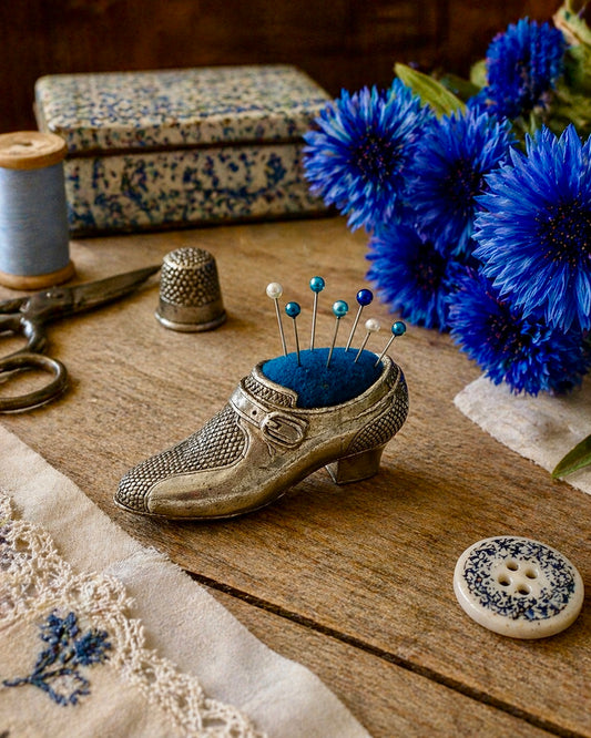 Puntaspilli vintage a guisa di deliziosa scarpetta argentata con cuscinetto blu