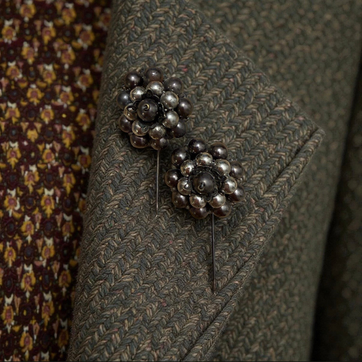 Coppia di gioielli da cappotto a spillo con asta in argento, fine ‘800 - primo ‘900