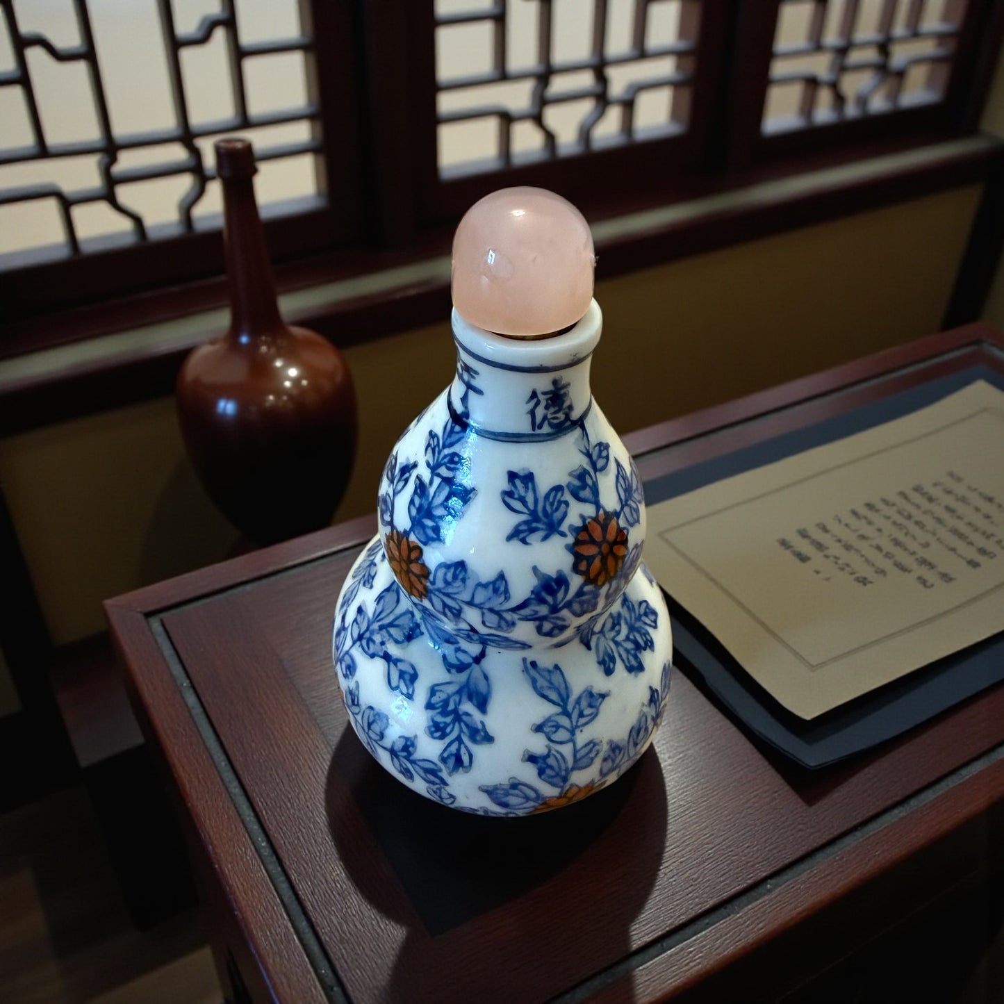 Snuff Bottle in ceramica smaltata a decori rossi e blu, tappo in quarzo rosa