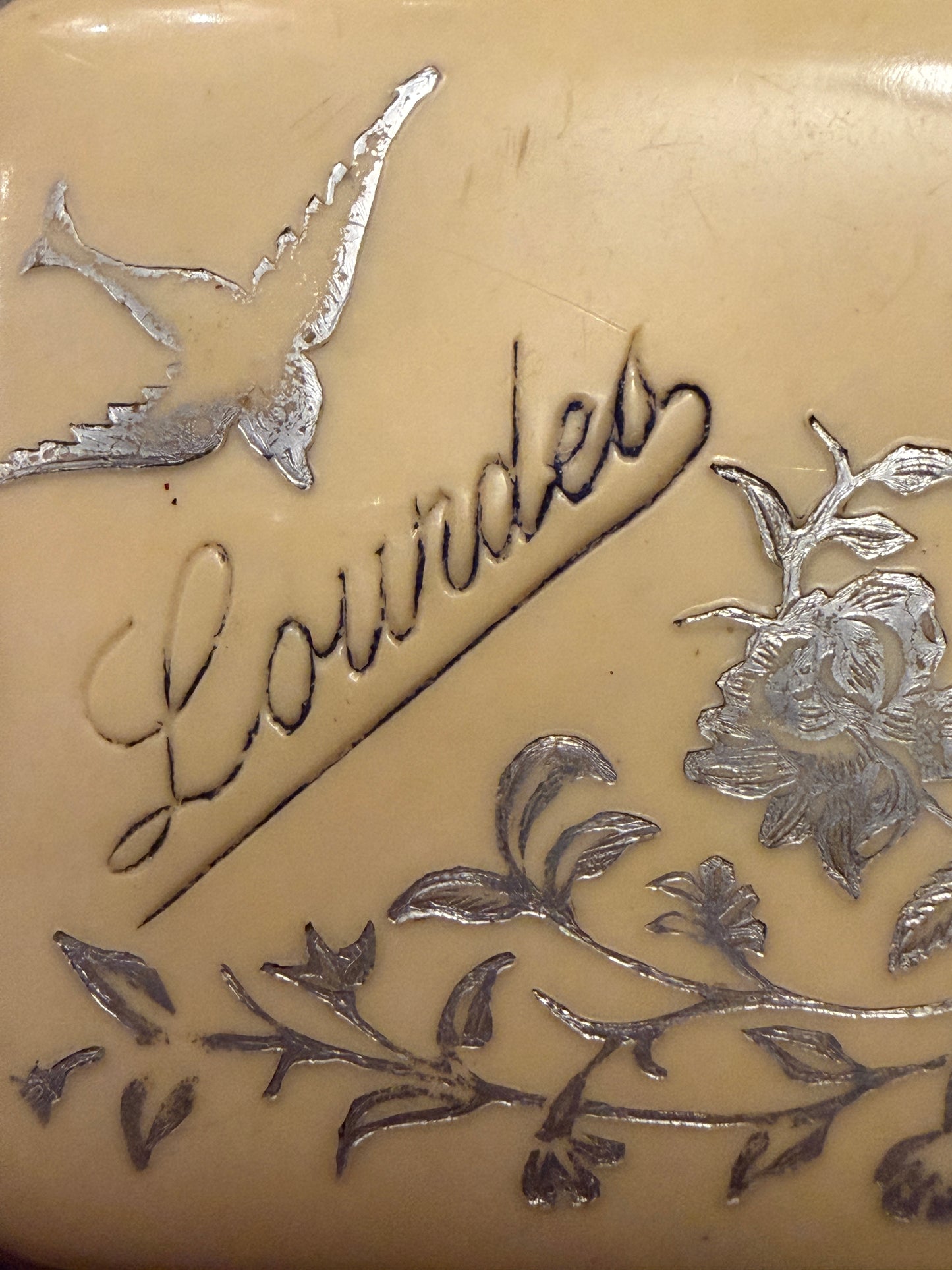 Porta monete antico in bachelite con decorazioni argentate floreali e scritta “Lourdes”