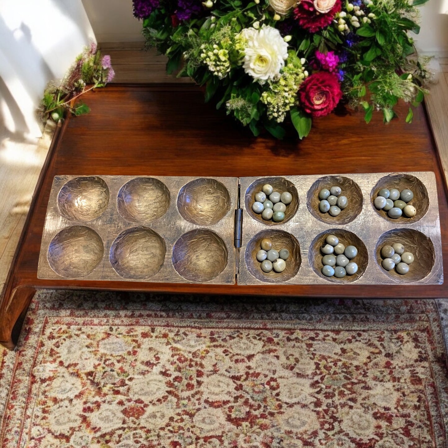 Antico gioco di semina Mancala orientale con semi di palma di montagna