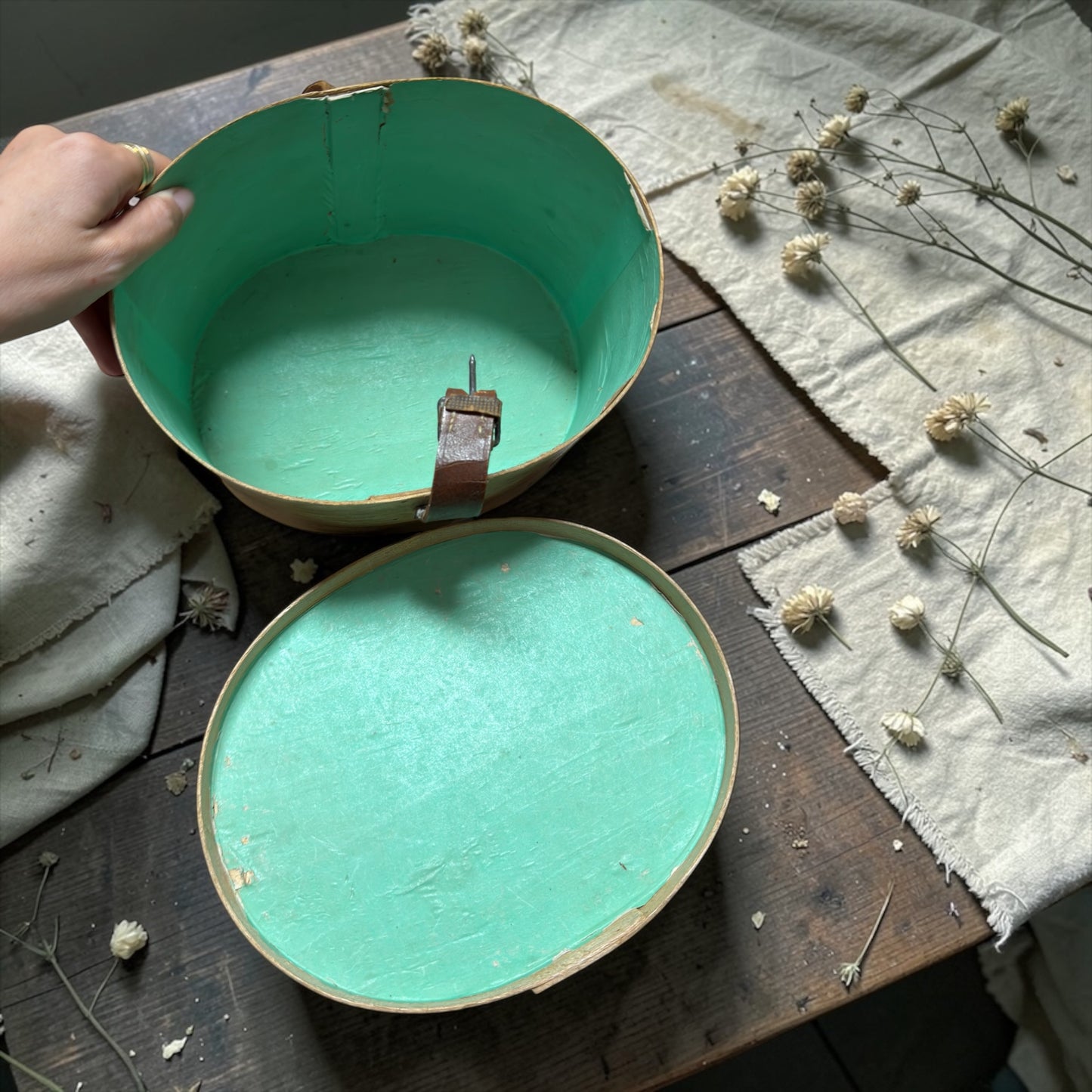 Coppia di antiche cappelliere da modista, foderate in carta verde, con cinghie originali d’epoca
