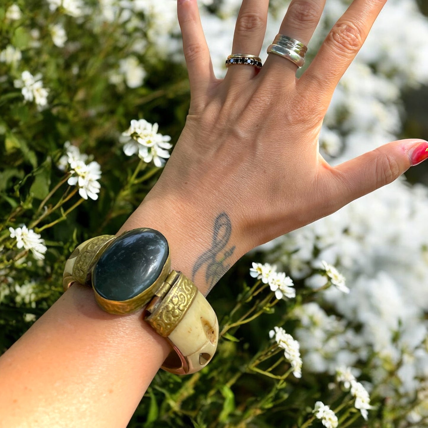 Bracciale rigido in osso con chiusura a baionetta, decorazioni in ottone e cabochon centrale pietra dura