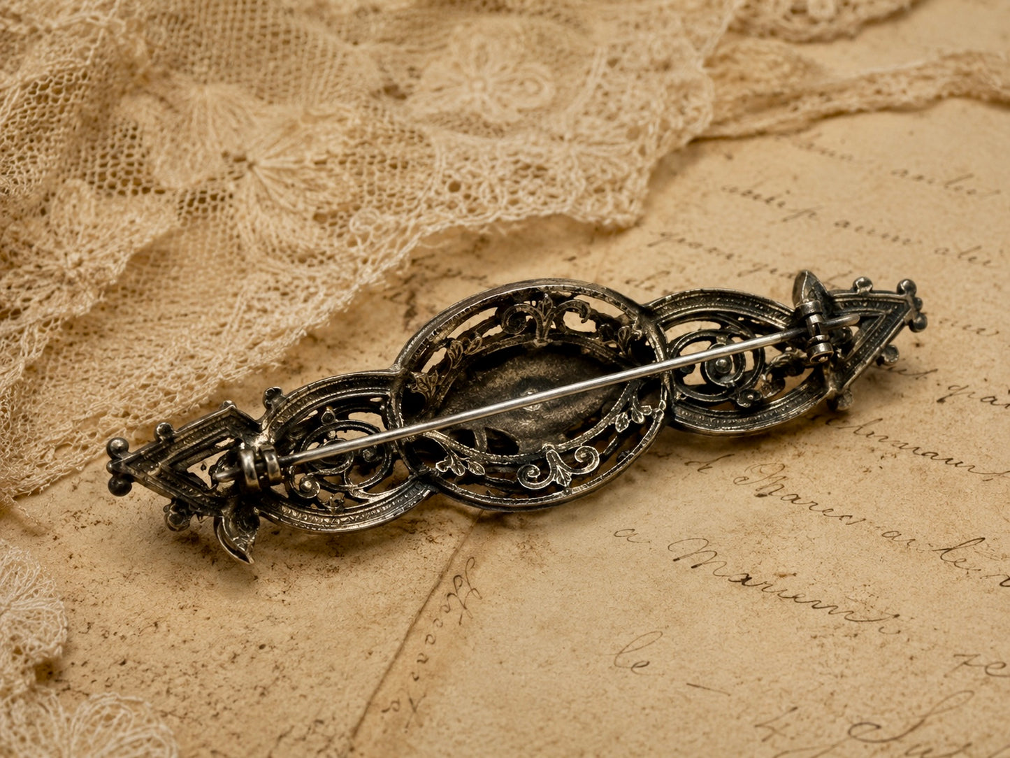 Spilla placcata argento con volute di rose e cabochon in ematite, anni ‘40