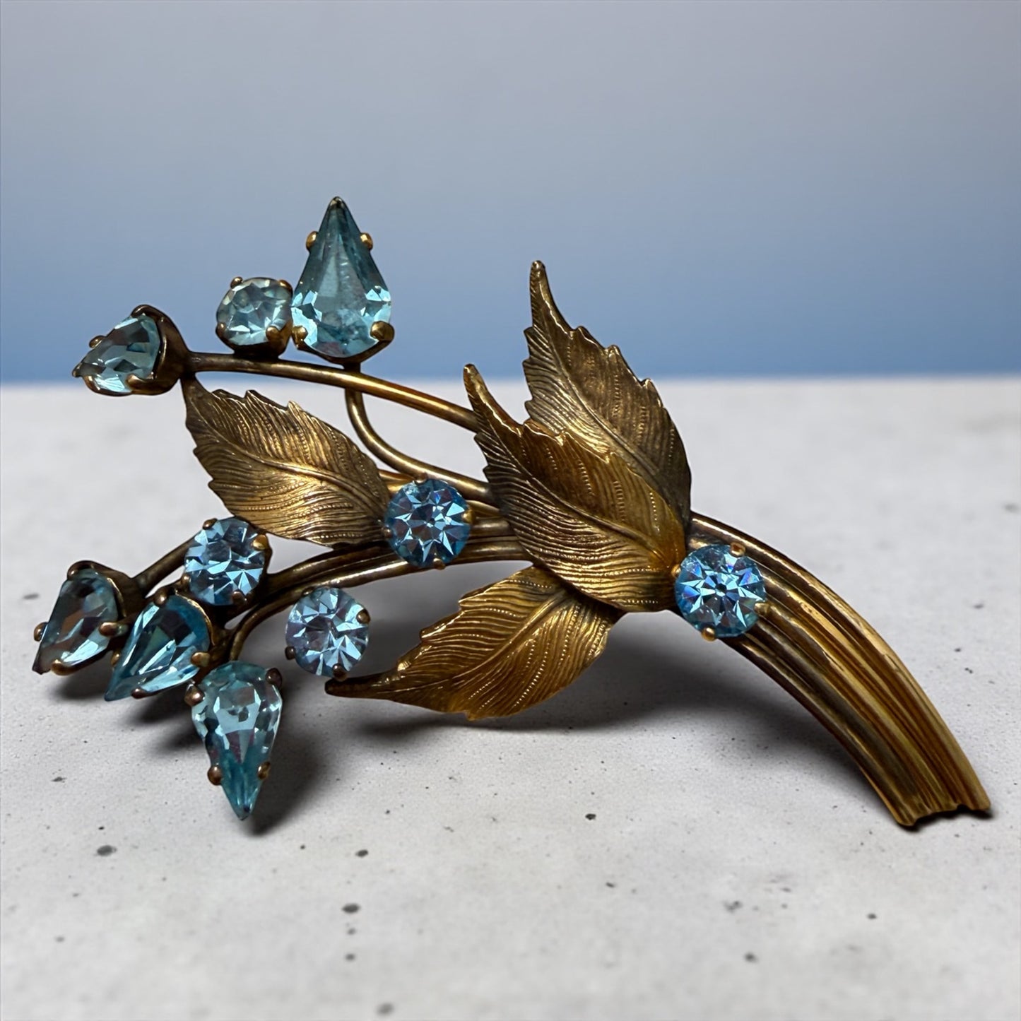 Spilla bouquet floreale anni ‘40 firmata, placcata oro con cristalli azzurri