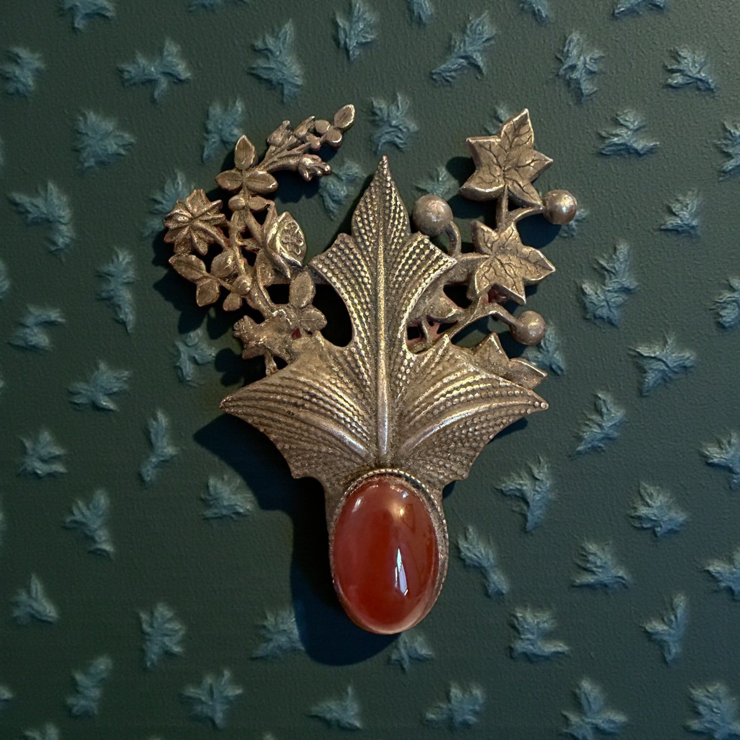 Splendida spilla in argento tardo Liberty con decorazioni fitomorfe e cuore in cornalina