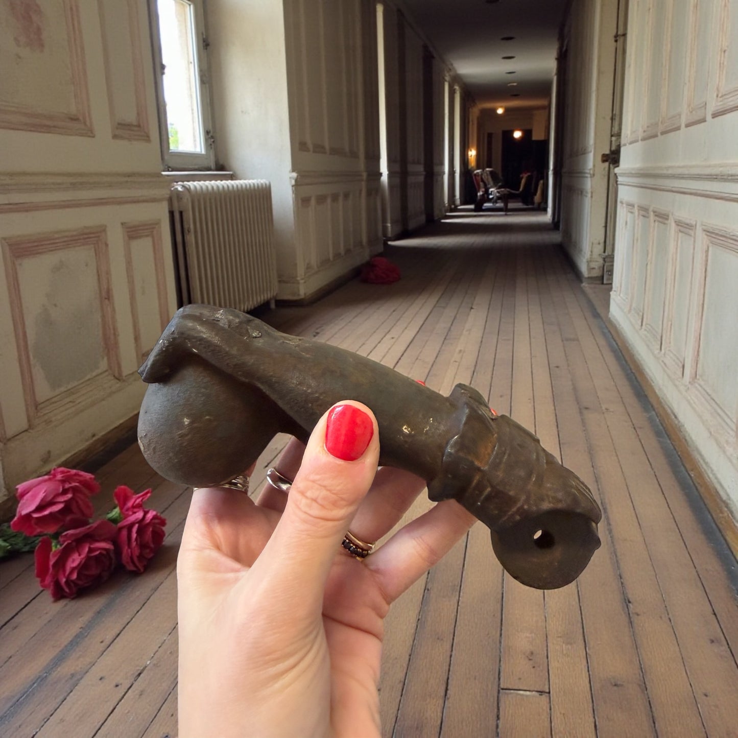 Battente antico in ghisa, mano femminile che bussa