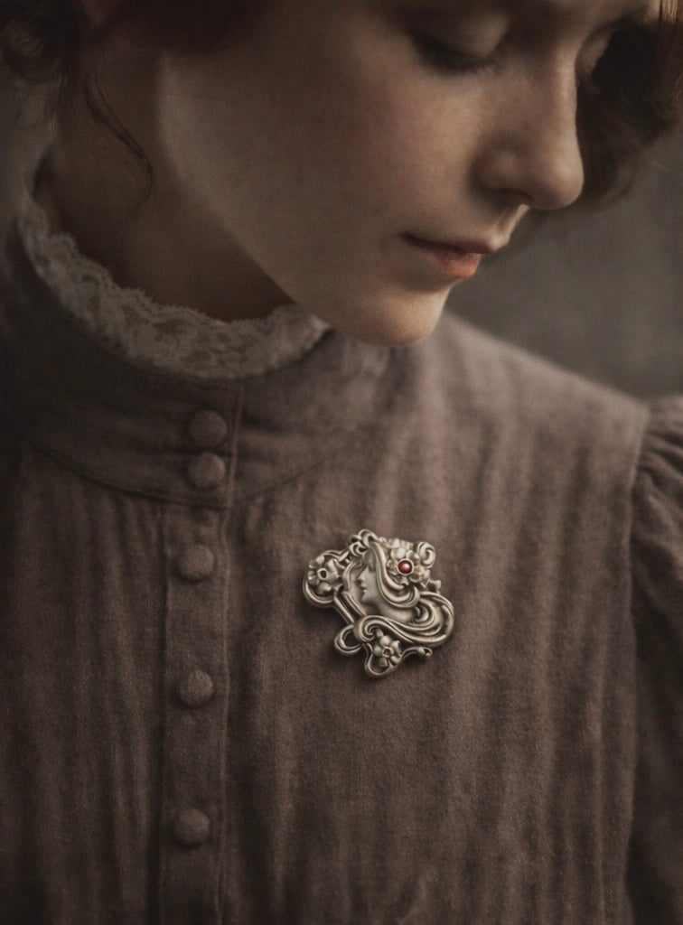 Spilla Liberty volto di donna con fiori e volute, pasta vitrea rosa, primo ‘900