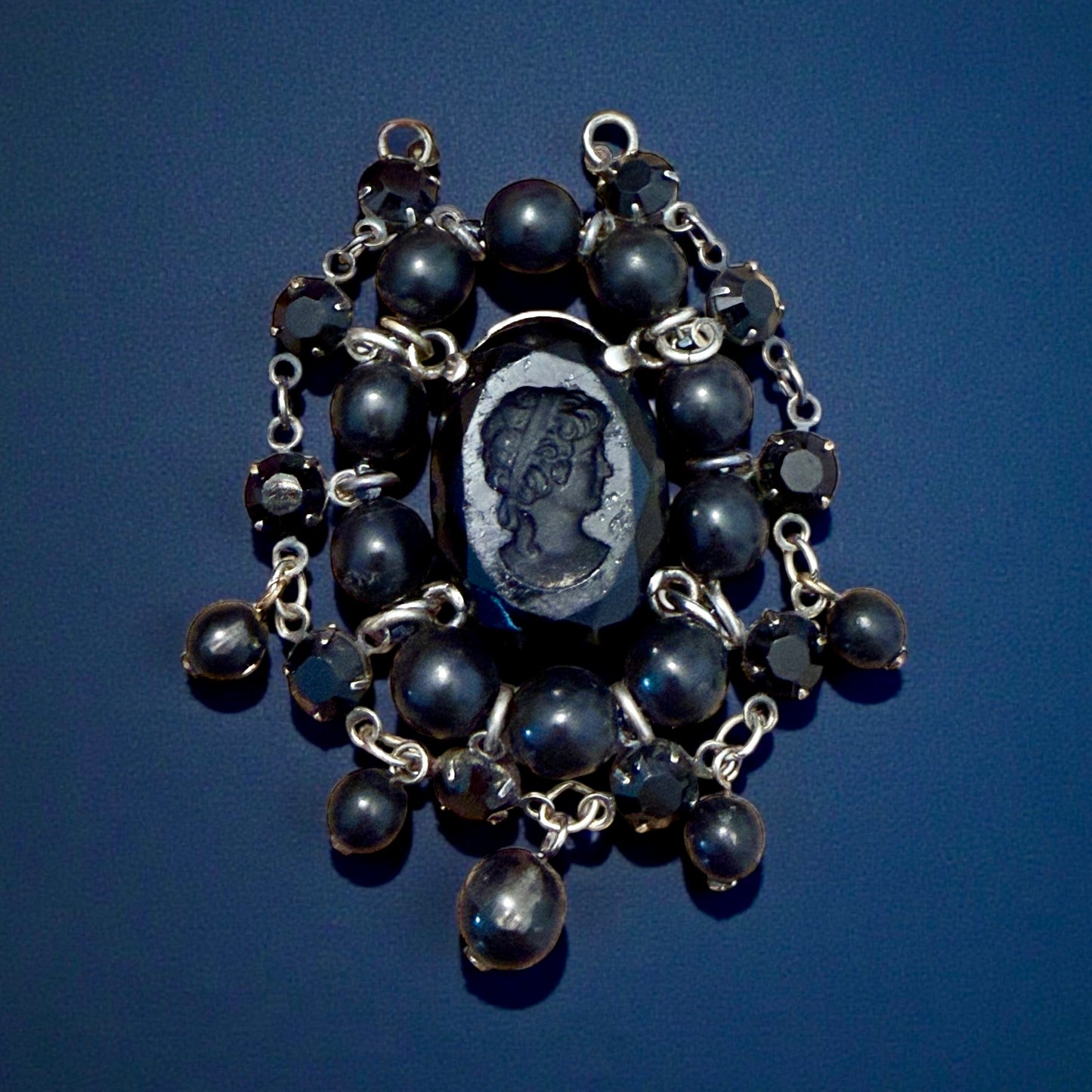 Pendente con paste vitree e perle plastiche e cammeo intagliato centrale montato in argento, anni ‘40.