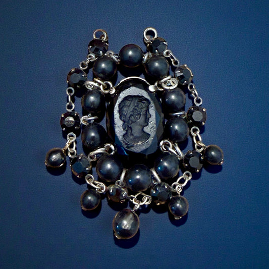 Pendente con paste vitree e perle plastiche e cammeo intagliato centrale montato in argento, anni ‘40.