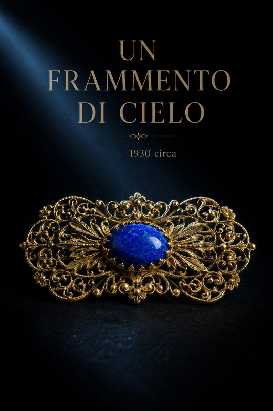 Spilla in filigrana di metallo dorato a guisa di pizzo con cabochon centrale blu
