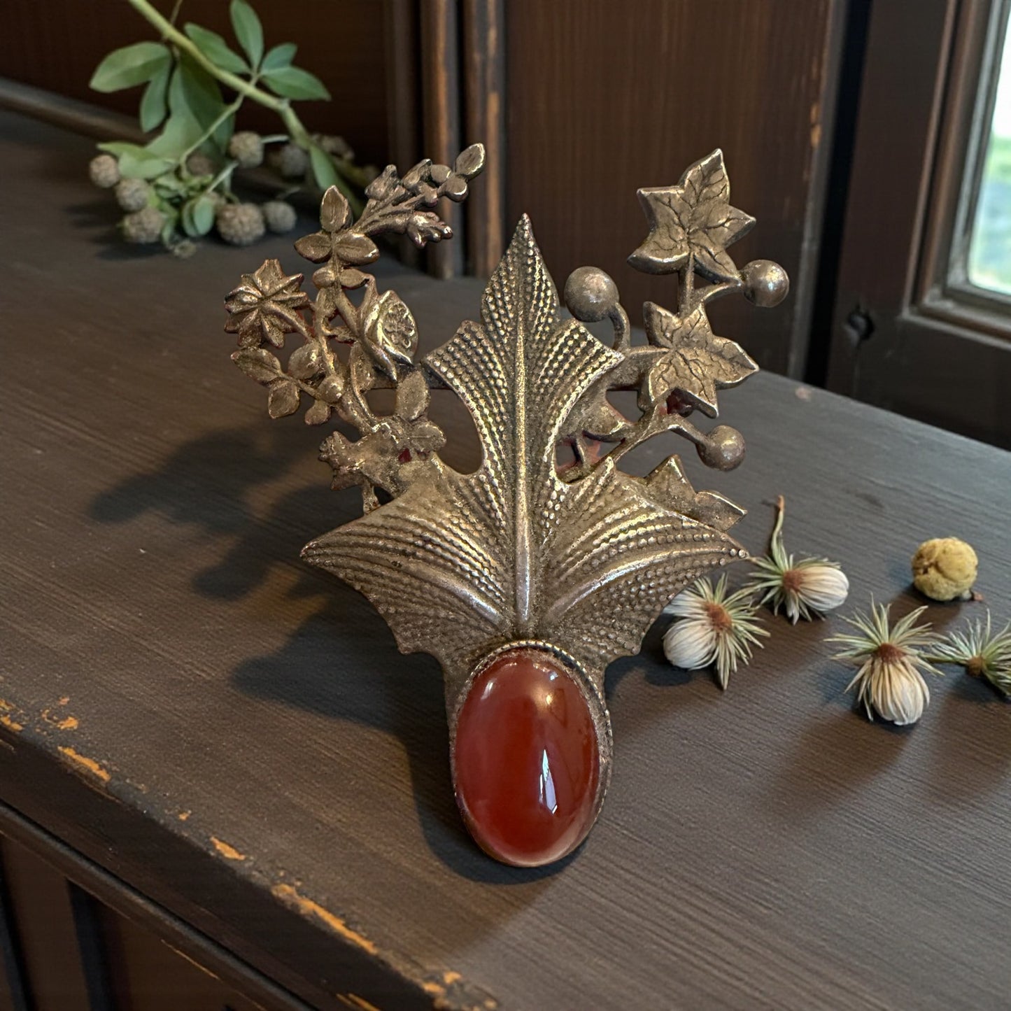 Splendida spilla in argento tardo Liberty con decorazioni fitomorfe e cuore in cornalina