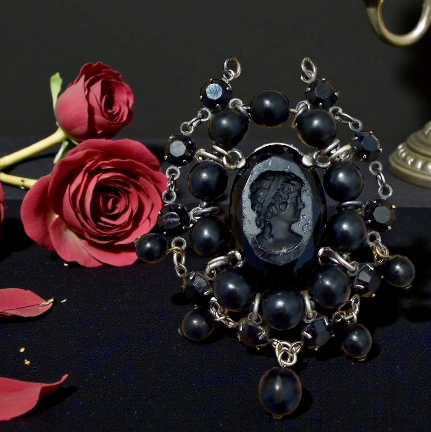 Pendente con paste vitree e perle plastiche e cammeo intagliato centrale montato in argento, anni ‘40.