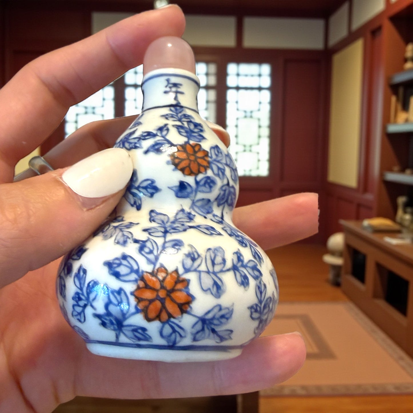 Snuff Bottle in ceramica smaltata a decori rossi e blu, tappo in quarzo rosa