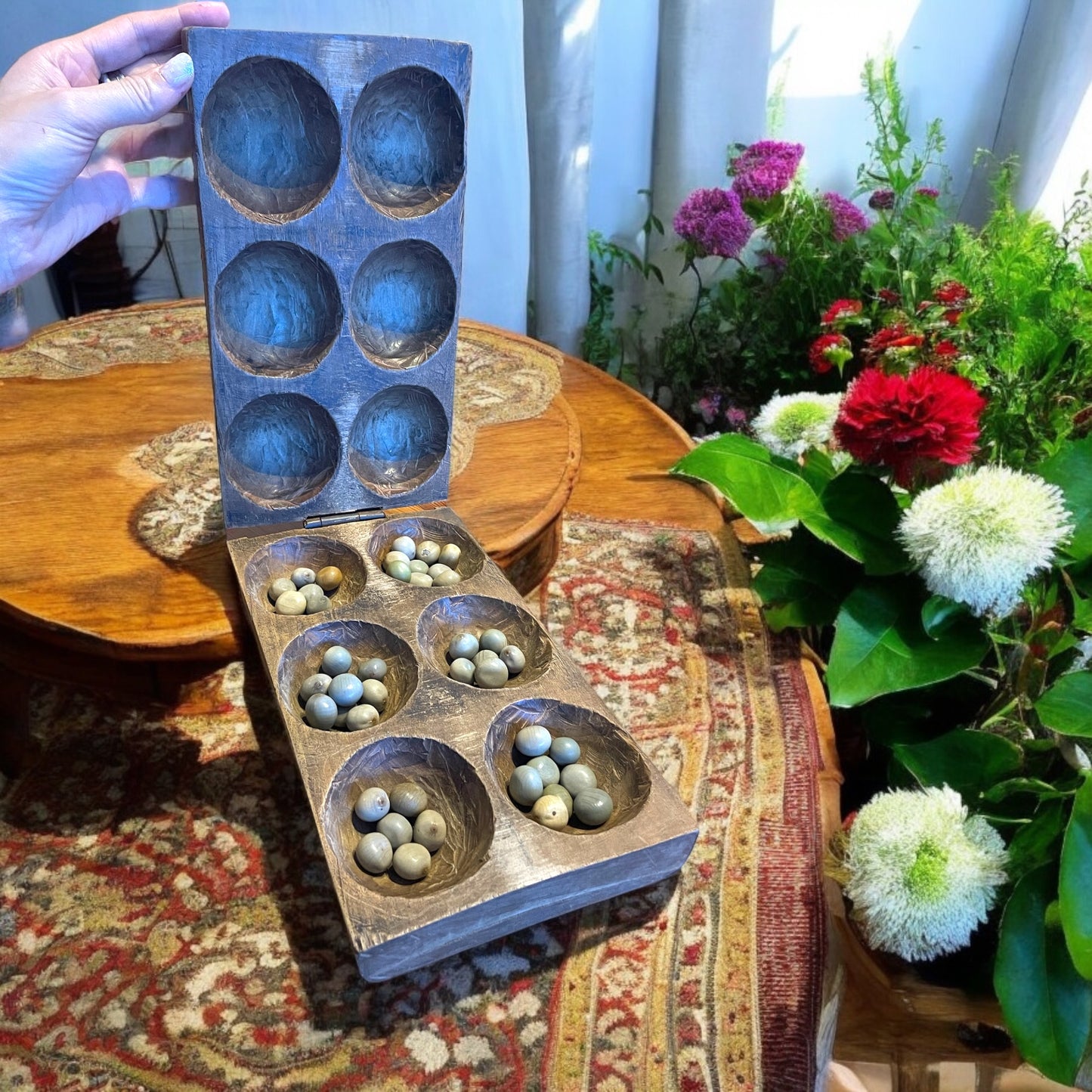 Antico gioco di semina Mancala orientale con semi di palma di montagna