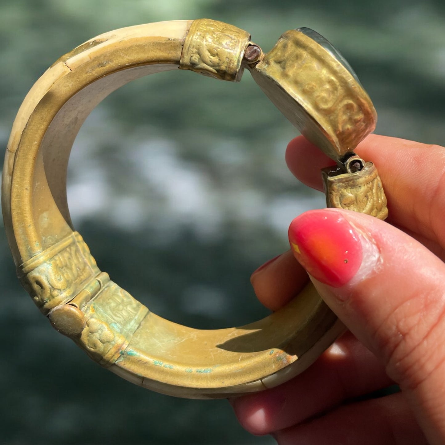 Bracciale rigido in osso con chiusura a baionetta, decorazioni in ottone e cabochon centrale pietra dura