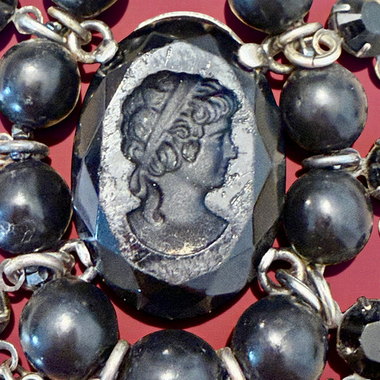 Pendente con paste vitree e perle plastiche e cammeo intagliato centrale montato in argento, anni ‘40.