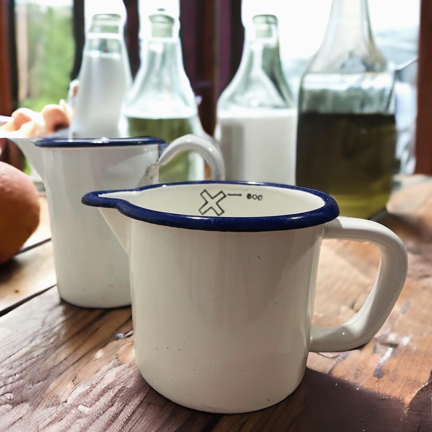 Pair of antique graduated enamel jugs