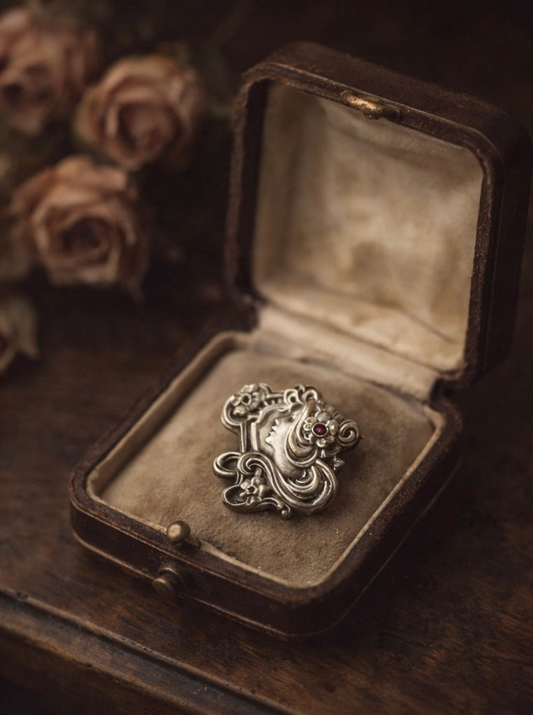 Spilla Liberty volto di donna con fiori e volute, pasta vitrea rosa, primo ‘900