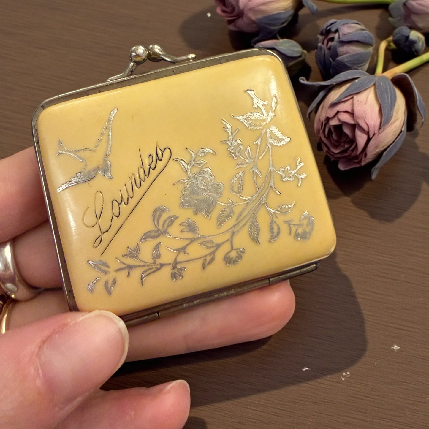 Porta monete antico in bachelite con decorazioni argentate floreali e scritta “Lourdes”