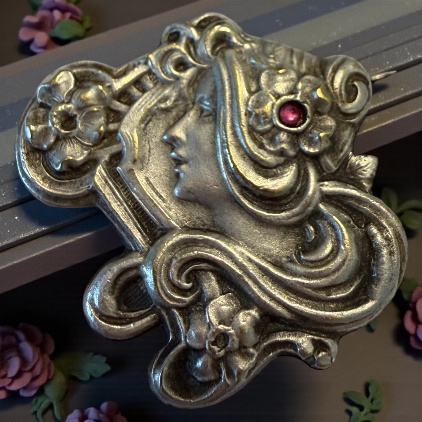 Spilla Liberty volto di donna con fiori e volute, pasta vitrea rosa, primo ‘900