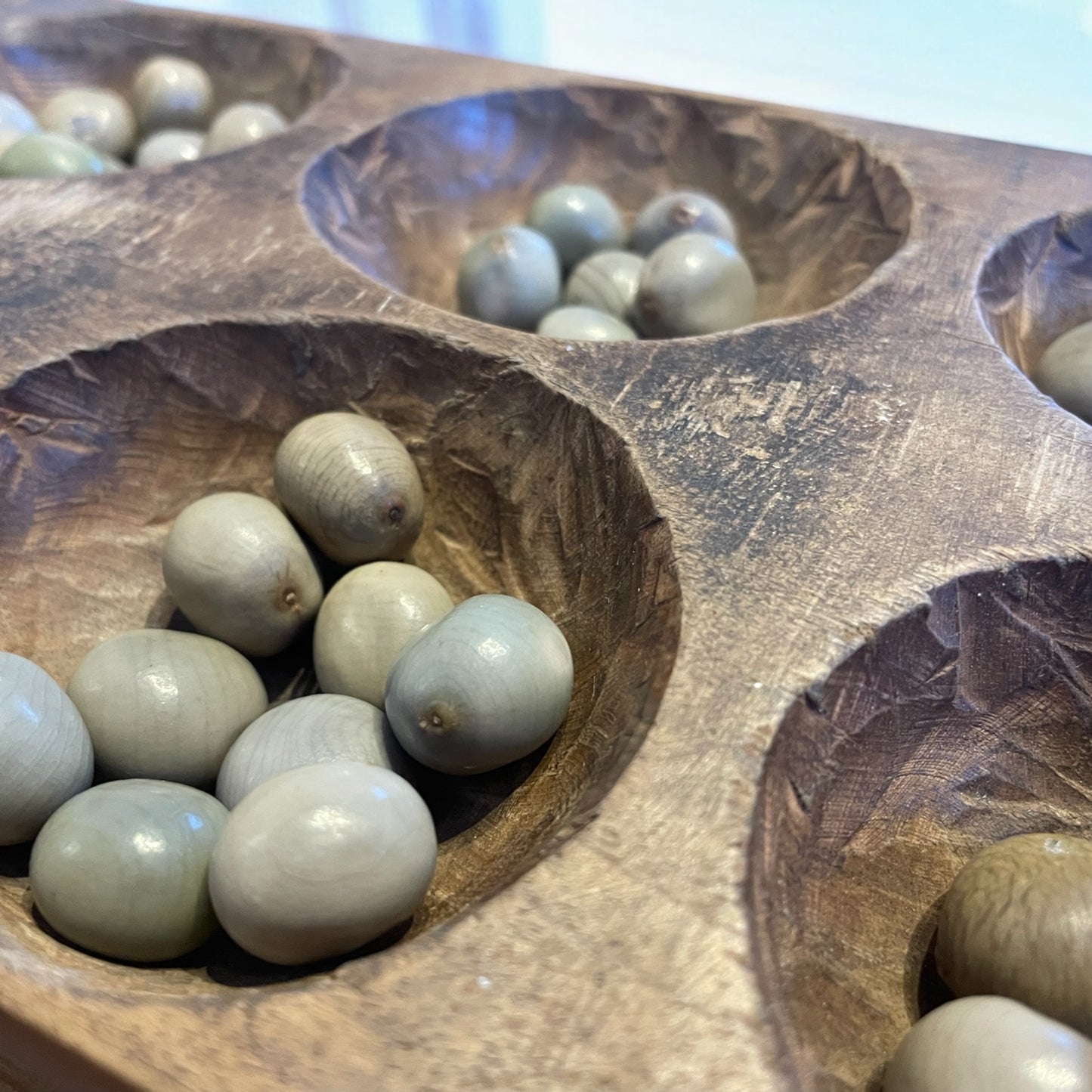 Antico gioco di semina Mancala orientale con semi di palma di montagna