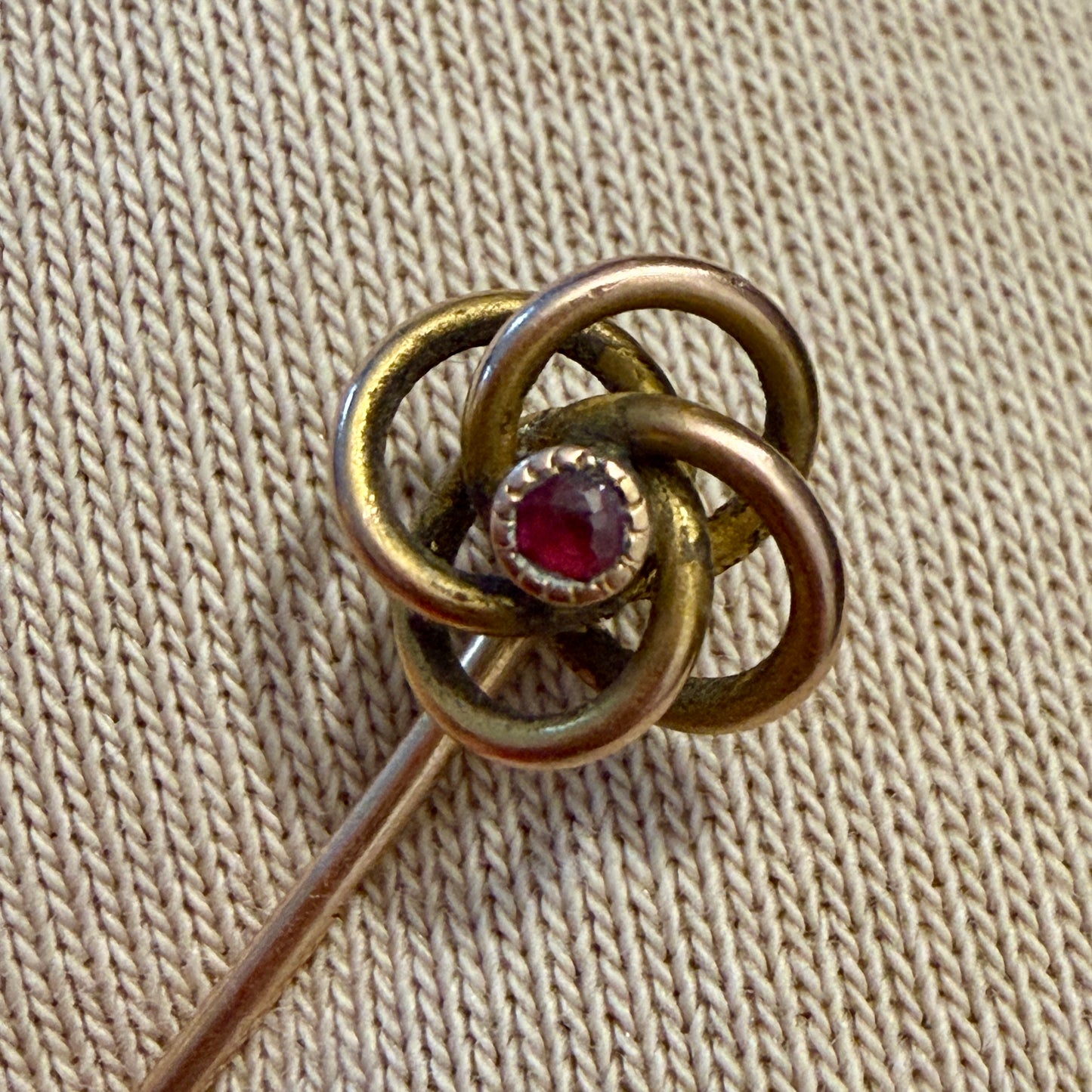 Spilla gioiello da cappotto placcata oro, nodo Liberty con piccolo granato