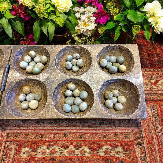 Antico gioco di semina Mancala orientale con semi di palma di montagna