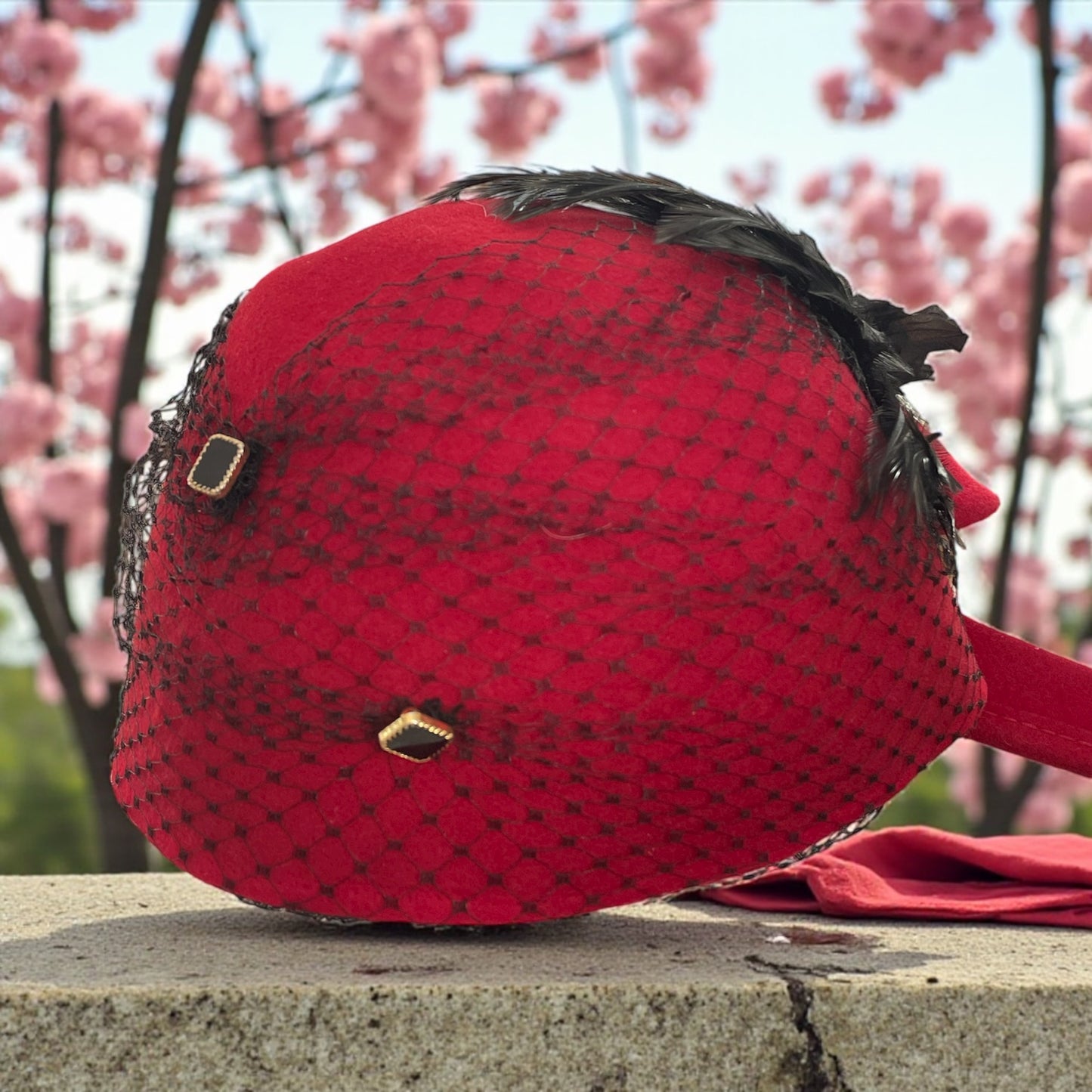 Cappellino anni ‘40 rivisitato da stilista con piume e veletta nera