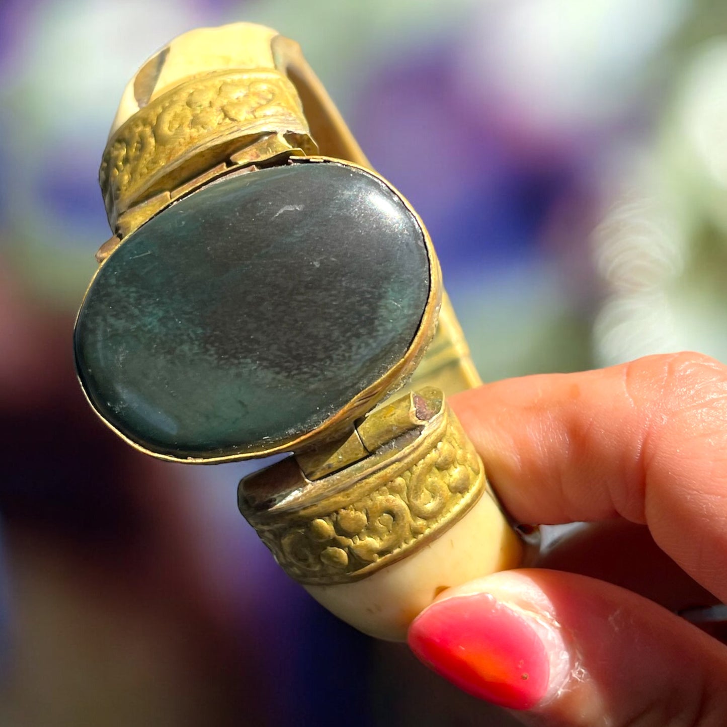 Bracciale rigido in osso con chiusura a baionetta, decorazioni in ottone e cabochon centrale pietra dura