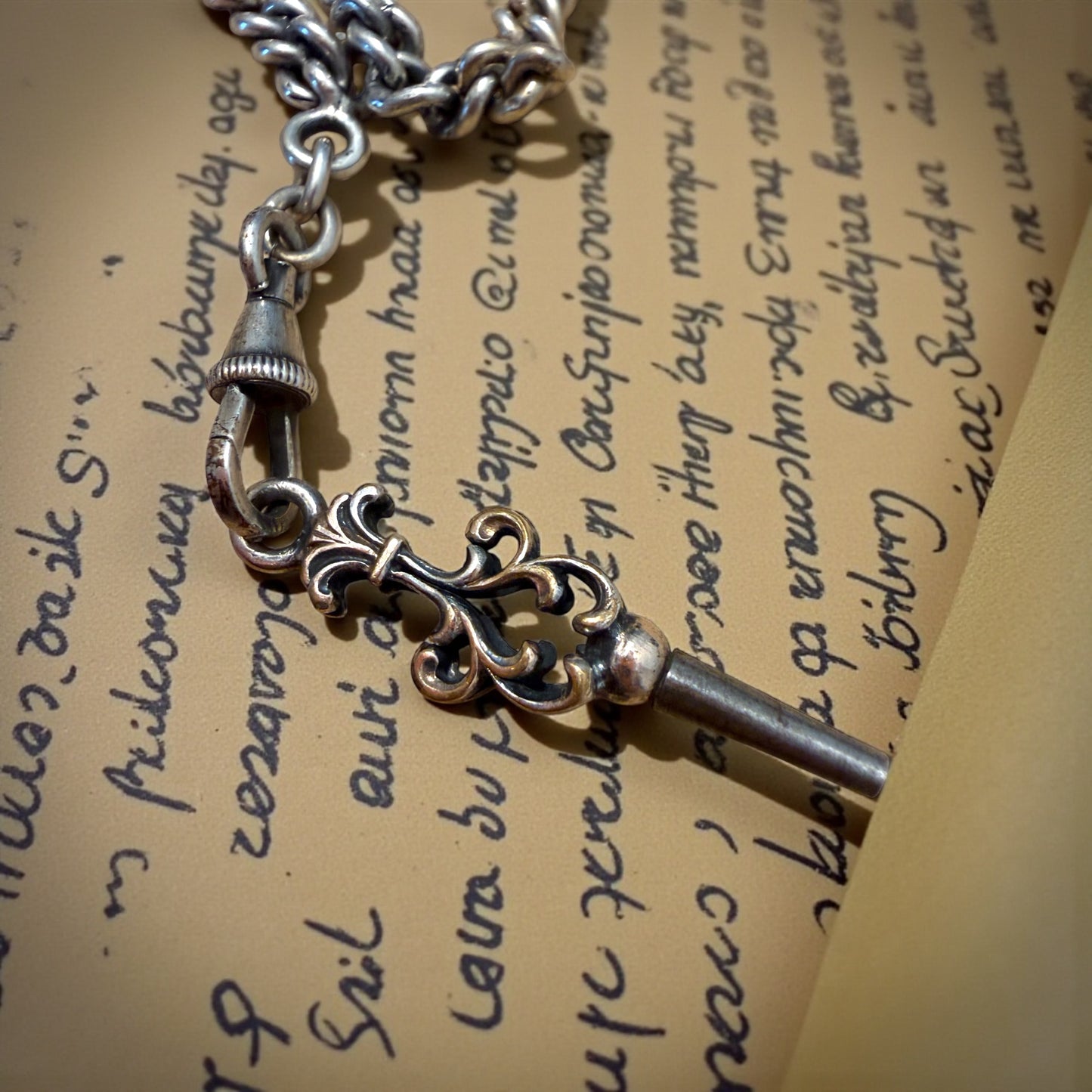 Gioiello maschile, tardo ottocentesco, catena da panciotto con chiave di carica e pendente fob